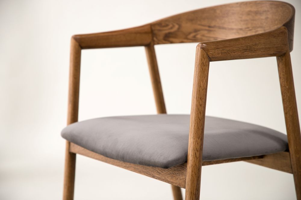 Elegant karmstol i tra med mjuk gra sits i tidlos design för alla rum.